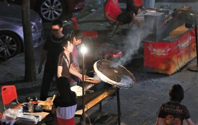 7月4日，青年路國美第一城小區(qū)附近的夜市臨街露天燒烤攤。