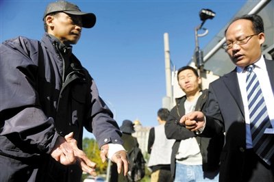常林鋒在法院外展示雙手，他稱被燙傷的手因刑訊逼供且未得到及時救治