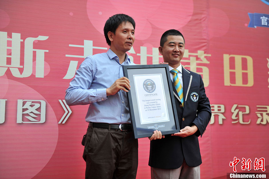 圖為世界吉尼斯認證官為鄭春輝（左）頒發(fā)證書。呂明 攝