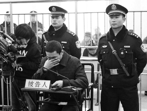 庭審中,29歲的李軍低著頭。