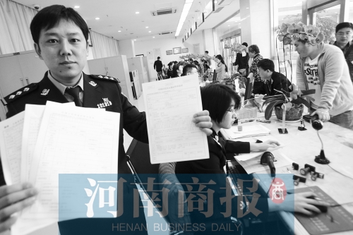 　民警左手拿的是新申請(qǐng)表，右手拿的是三份老申請(qǐng)表 王春勝/攝