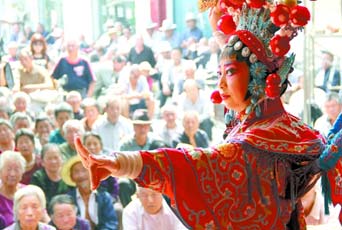 圖為8月15日戲曲演員在“流動舞臺車”上表演傳統(tǒng)地方戲《穆桂英下山》。