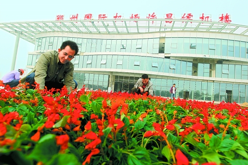 9月23日，工人們正在鄭州國際機場許昌候機樓前擺放鮮花。