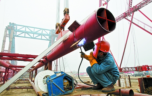 2月25日，在跨越南水北調(diào)總干渠的鄭州新鄭南段十里鋪公路橋施工現(xiàn)場，建設(shè)者在緊張地施工。