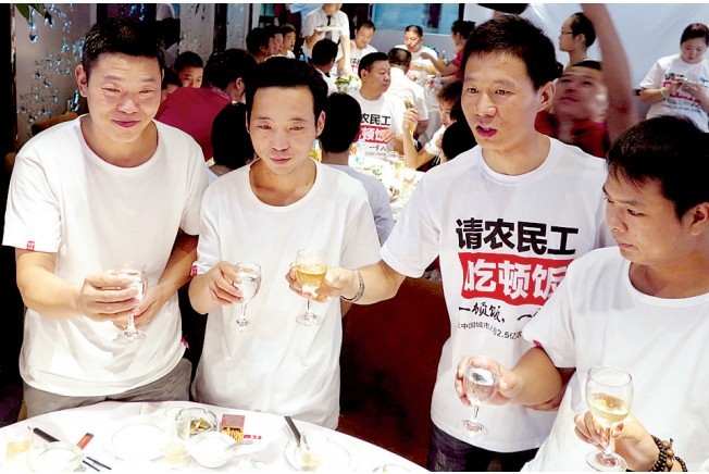 活動(dòng)發(fā)起人張楠（右二）給農(nóng)民工敬酒。