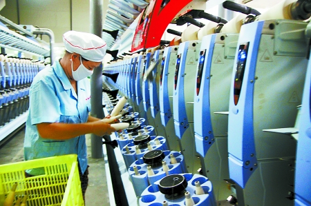 7月3日，在鄧州市永泰棉紡有限公司電腦控制全自動(dòng)紡紗車間，紡織工人正在生產(chǎn)棉紗。