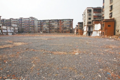 為降塵，旮旯王村拆遷后裸露的地面上鋪了一層石子。