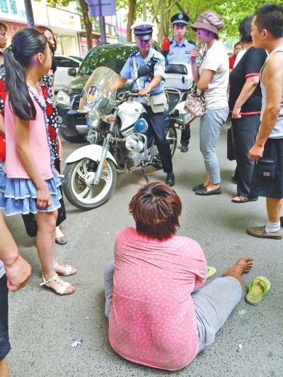 在鄭州優(yōu)勝南路東三街交叉口向東100米處，一名短發(fā)中年女子平躺在路南快車道上，身旁還有一只掉落的拖鞋