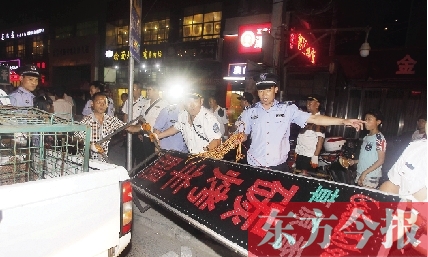 7月8日晚，鄭州市商城路一家占道經(jīng)營(yíng)的攤販招牌被執(zhí)法隊(duì)員“登記保存”