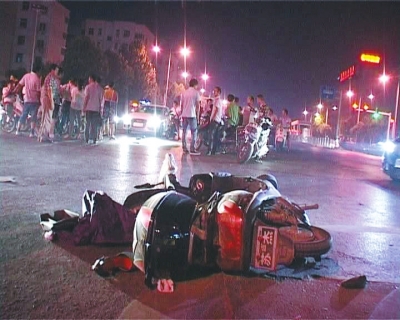 一輛白色無牌奧迪轎車在通過路口時(shí)，將一名騎電動(dòng)車的女子撞飛十多米