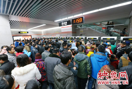 地鐵開通首日，上午十一點五十九分，紫荊山地鐵站售票機前擠滿了買票的市民。