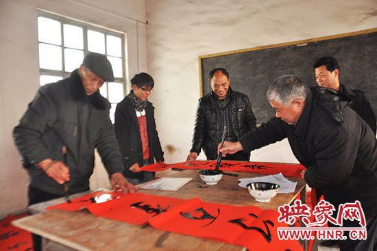 鞏義市魯莊鎮(zhèn)農(nóng)民書法愛好者正在寫春聯(lián)。