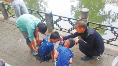 男孩被救出后，圍觀群眾幫他控水換衣服。