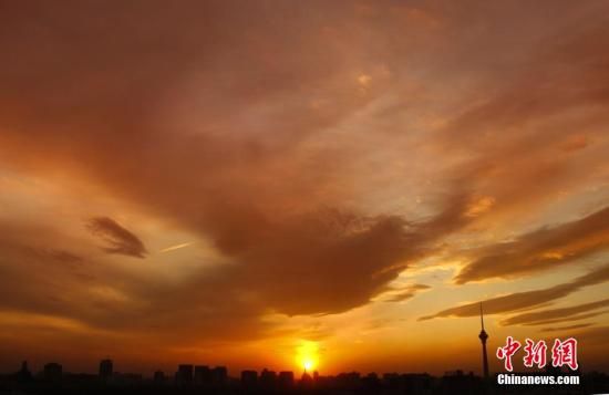 12月8日下午，強(qiáng)烈的西北風(fēng)光臨北京，吹散了籠罩全城上空的霧霾，冬日罕見的艷麗晚霞映紅了半邊天。