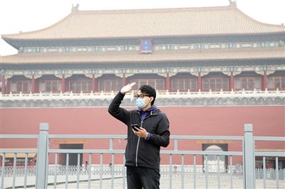 11月1日，北京大部分地區(qū)重度污染，一名游客戴著口罩在午門前揮手跟朋友打招呼。 實習(xí)生 王飛 攝