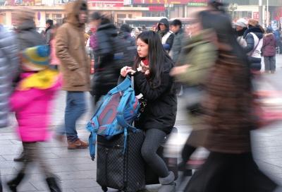 春運(yùn)首日，北京站客流量明顯增多，一名女孩在人流中等待進(jìn)站。