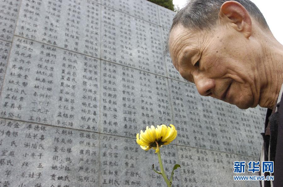 2006年4月5日，74歲的南京大屠殺幸存者佘子清手捧鮮花，祭奠被日軍殺害的母親。
