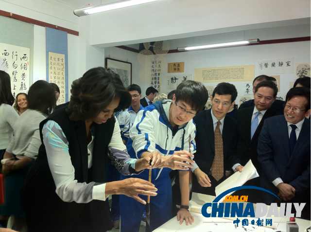 北京時間3月21日，美國第一夫人米歇爾參觀北師大二附中時，與學(xué)生一起練習(xí)書法。