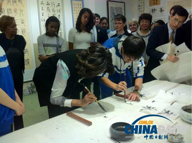 　北京時間3月21日，美國第一夫人米歇爾參觀北師大二附中時，與學(xué)生一起練習(xí)書法。
