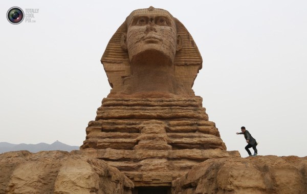 石家莊郊外，一名男子與山寨版獅身人面像合影留念。