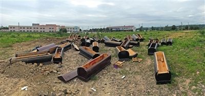 40多副棺木被砸壞后，扔在荒地上。