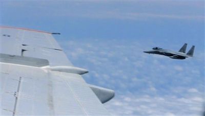 國防部網(wǎng)站12日公布的視頻截圖,日本F-15軍機從中國圖-154機頭方向危險切入,兩者最近距離約30米左右。