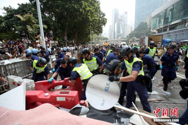 10月14日，警方清除金鐘道障礙物。大批警員在金鐘道現(xiàn)場(chǎng)清拆障礙物。部分警員戴上頭盔將障礙物移走。