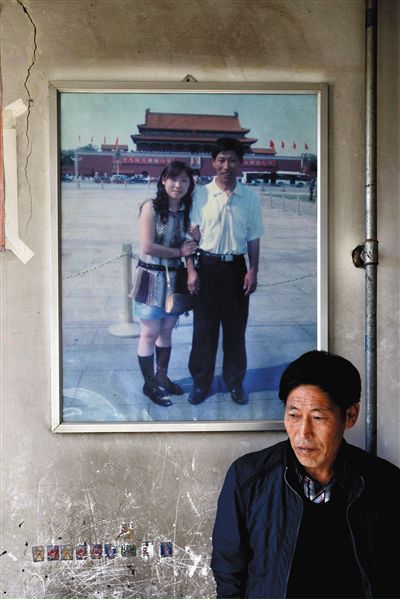 11月14日，承德市平泉縣，潘小梅父母的家，潘小梅父親靠在墻上，身后掛著數(shù)年前他和潘小梅在北京的合影照片。新京報(bào)記者
