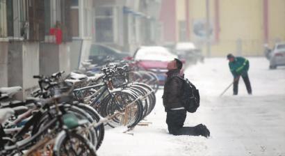 小伙子跪在樓前，一直抬頭看著樓上。 孫立國/攝