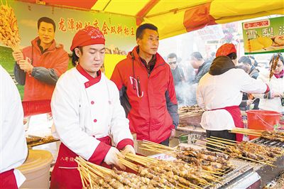 賣羊肉串?dāng)偽焕习遐w山（穿紅衣者）。新京報記者