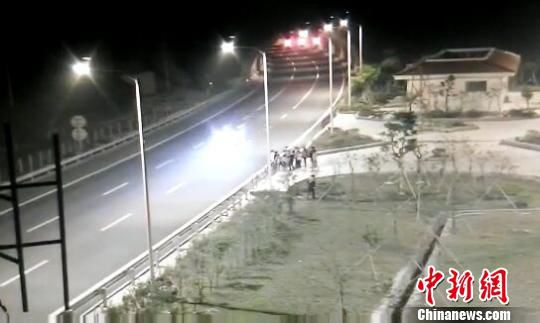 看到車輛經(jīng)過，孩子們便急忙跑到一旁的花圃上?！【焦﹫D　攝