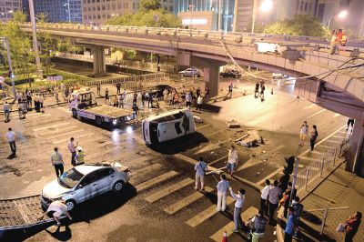 路虎沖下國(guó)貿(mào)橋砸中一輛起亞轎車，橋上厚達(dá)幾十厘米的水泥護(hù)欄被撞斷，碎石四處散落，數(shù)十群眾在現(xiàn)場(chǎng)圍觀。