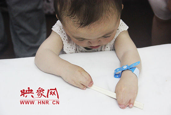 孩子握著筷子發(fā)呆。