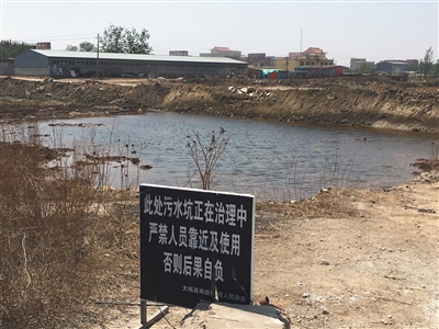 化肥廠滲坑的三分之一經(jīng)過治理，但水質(zhì)仍然呈黃褐色。