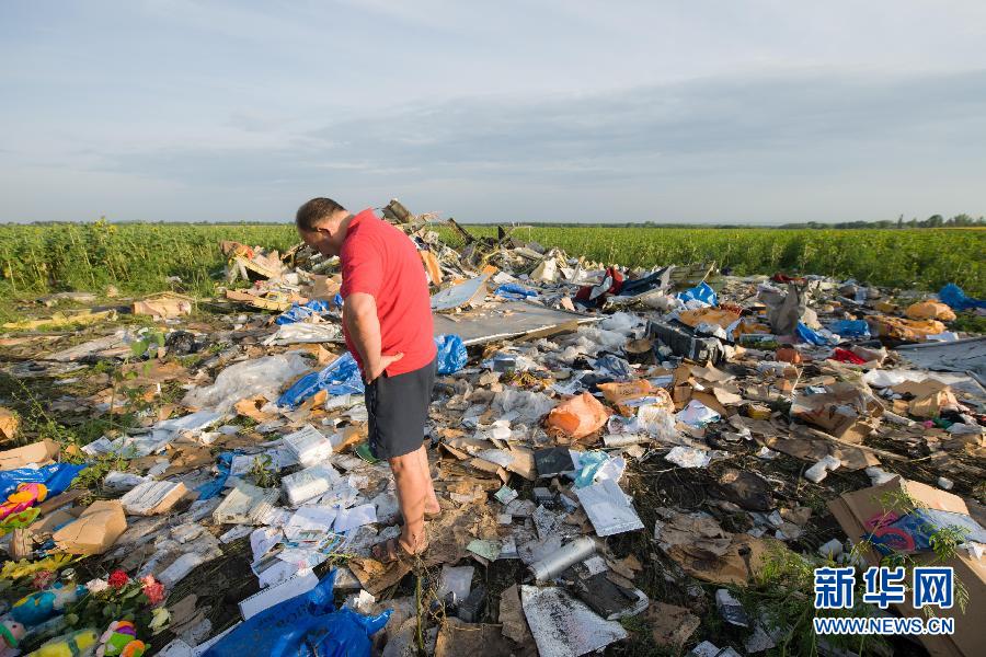 　7月19日,在烏克蘭頓涅茨克州,一名當?shù)孛癖娬驹隈R航MH17航班墜機現(xiàn)場。