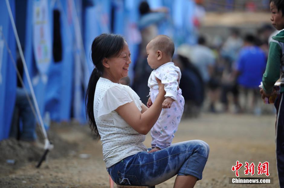 8月6日，一名年輕的母親在和孩子玩樂。