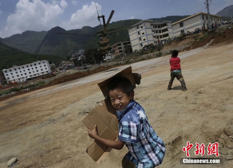 云南省昭通市魯?shù)榭h發(fā)生6.5級地震。幾個孩子在直升機(jī)降落的平地上玩耍。