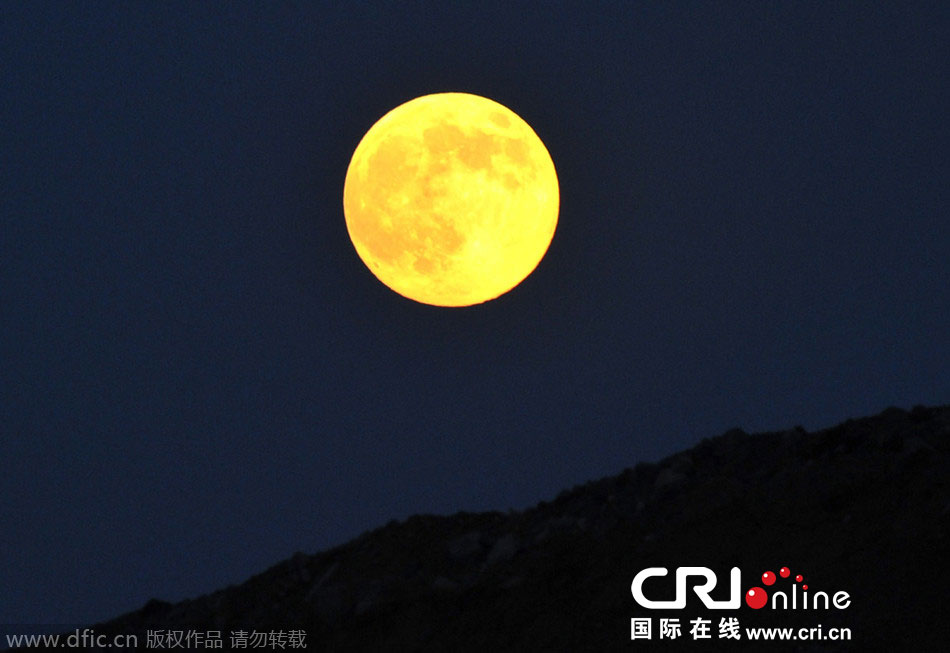 8月10日晚，一輪金燦燦的大月亮在遼寧省大連市東方升起。圖片來源：劉德斌/東方IC