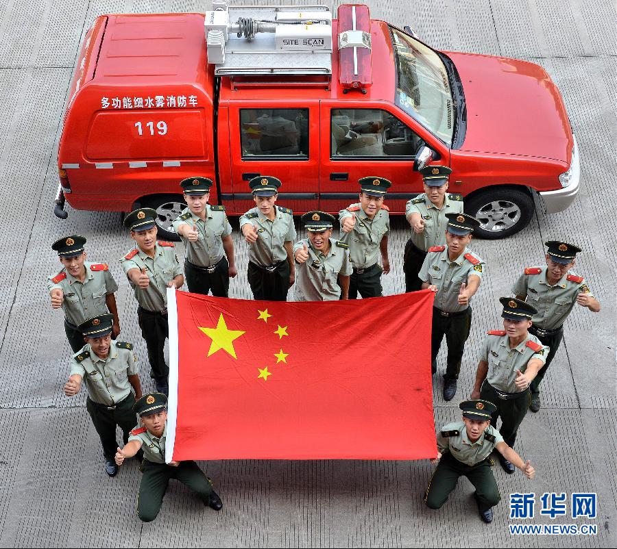  9月25日，武警浙江嘉興消防官兵與國(guó)旗合影。