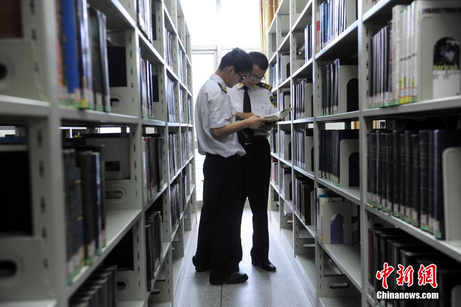 5月8日，武漢輕工大學(xué)保安吳濤與江力在圖書館交流學(xué)習(xí)。中新社發(fā) 張暢 攝