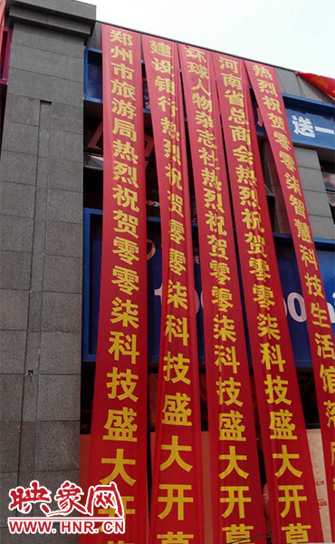 路邊一棟樓上懸掛著二三十條紅色條幅，全部是祝賀一家公司開業(yè)的。