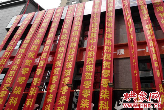 路邊一棟樓上懸掛著二三十條紅色條幅，全部是祝賀一家公司開業(yè)的。