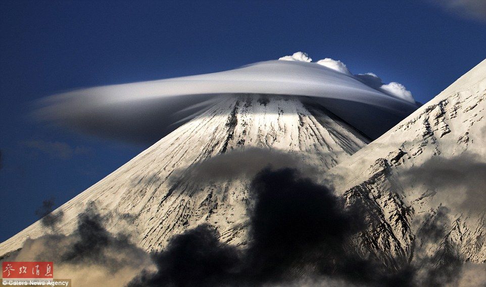 火山上籠罩著類似于外星飛碟形狀的云彩，場景猶如科幻大片。
