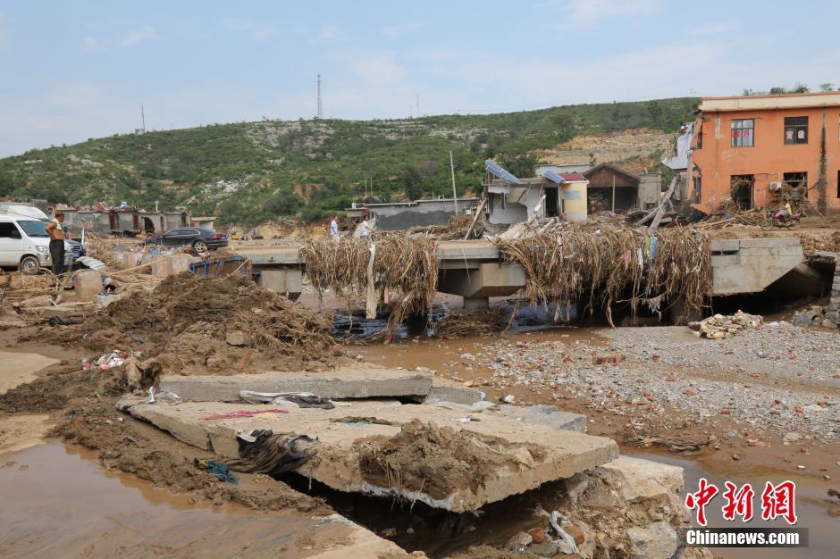圖為洪水過后，坍塌的橋梁上遺落大量雜草。