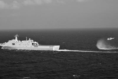 11日，抵達馬航飛機失聯(lián)海區(qū)的海軍井岡山艦與艦載直升機協(xié)同展開立體搜救行動。新華社發(fā)