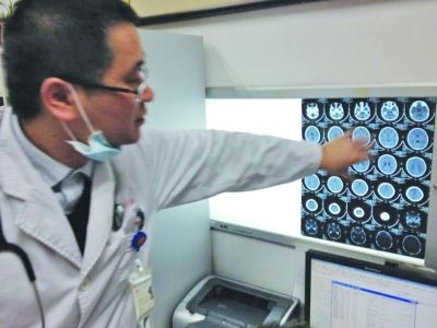 醫(yī)生在查看男孩的腦部CT片。薛馬義 攝