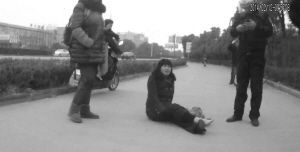 鄭大姐坐在地上，警方趕到進行施救。（視頻截圖由警方提供）