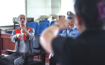 張志國在法庭上用手語回答提問。記者 蒲東峰攝