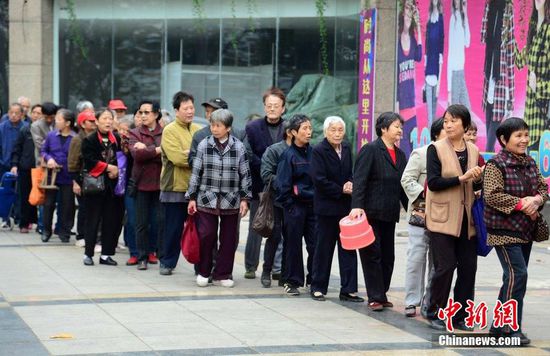 圖為10月28日，在江西九江市一家羊絨皮草服裝服飾博覽會(huì)現(xiàn)場(chǎng)，老人們正在頂著寒風(fēng)排隊(duì)等待領(lǐng)取10元代金劵。