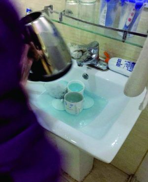 酒店服務(wù)員用潔廁液刷燒水壺和茶杯。